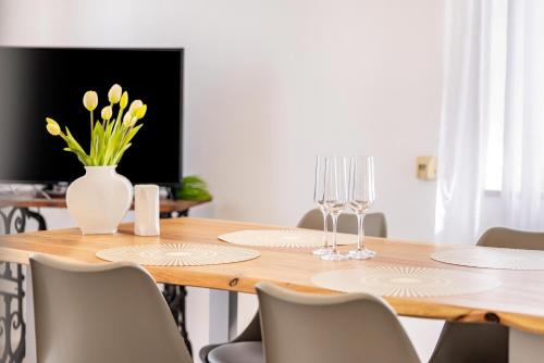 a dining room table with a vase of flowers and wine glasses at Apartment Alb Glück 2 in Hechingen