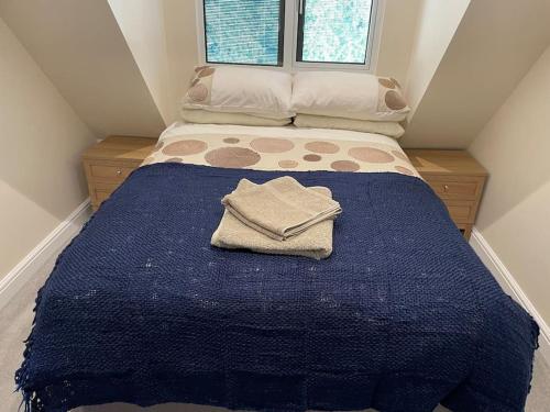 a small bedroom with a blue bed with a blue blanket at Cotswold self-catering apartment in Cirencester