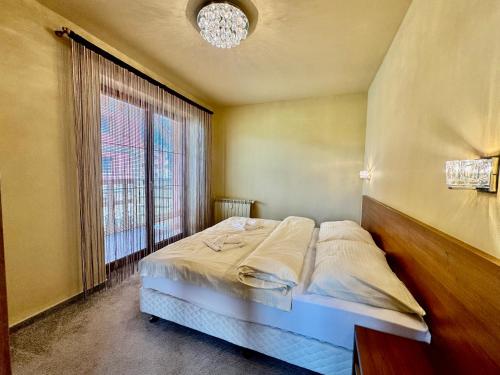 a bed in a room with a large window at Tatragolf Resort Apartment I206 Tatranská Lomnica in Veľká Lomnica