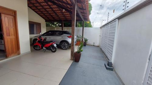 a car parked in a garage next to a motorcycle at Casa Mobiliada para o período do Festival Folclórico de Parintins 2024 in Parintins