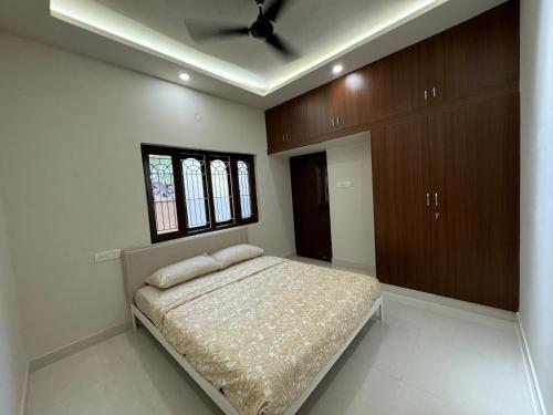 a bedroom with a bed and a ceiling at Maple Grove Traditional Homes. in Bangalore