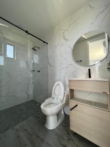 a bathroom with a toilet and a sink and a shower at PALO ALTO - EXCLUSIVA CASA DE CAMPO in Restrepo