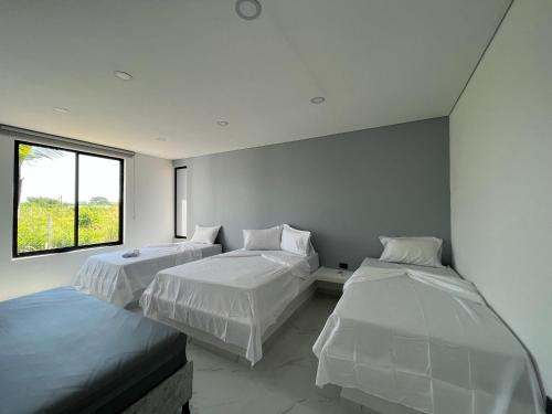 a bedroom with two beds and a window at PALO ALTO - EXCLUSIVA CASA DE CAMPO in Restrepo