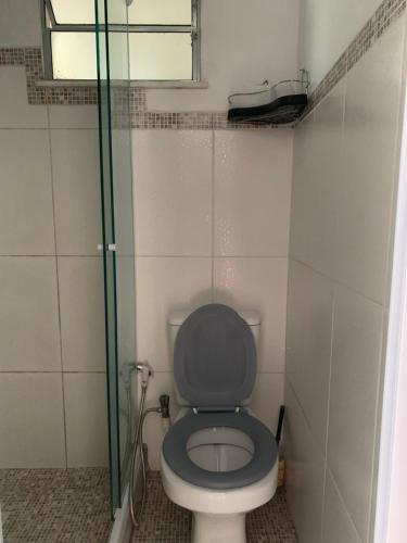 a bathroom with a toilet with a glass door at Farol do cais in Niterói