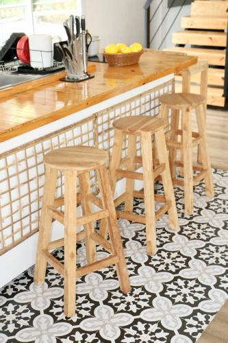 a kitchen with three wooden stools in front of a counter at Maryland Khaoyai Annapolis Pool Villa in Ban Nong Song Hong