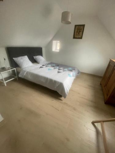 Schlafzimmer mit einem Bett und Holzboden in der Unterkunft maison de campagne le GAULT 