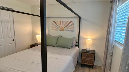 1 Schlafzimmer mit einem Himmelbett und 2 Lampen in der Unterkunft Turtle Nest 8 - Quick Walk to Beach in Fort Myers Beach