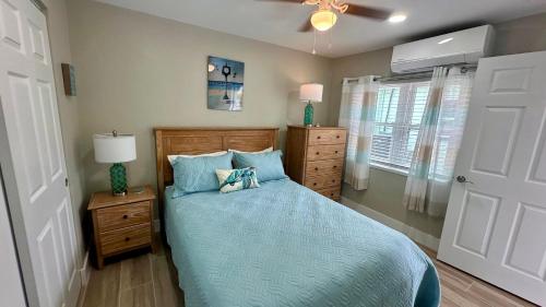 1 dormitorio con 1 cama con edredón azul en Turtle Nest 2 - Quick Walk to Beach, en Fort Myers Beach
