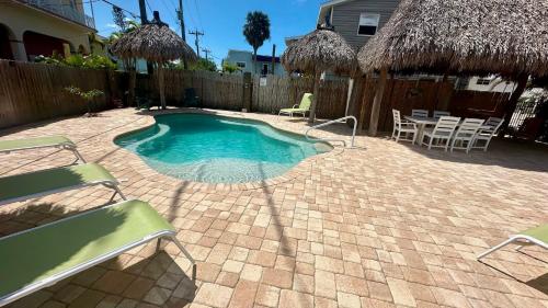 einen kleinen Pool mit Stühlen und eine Terrasse in der Unterkunft Turtle Nest 8 - Quick Walk to Beach in Fort Myers Beach