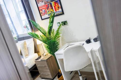 a desk with a chair and a plant in a room at Trendy Rooms Spitalfields in London