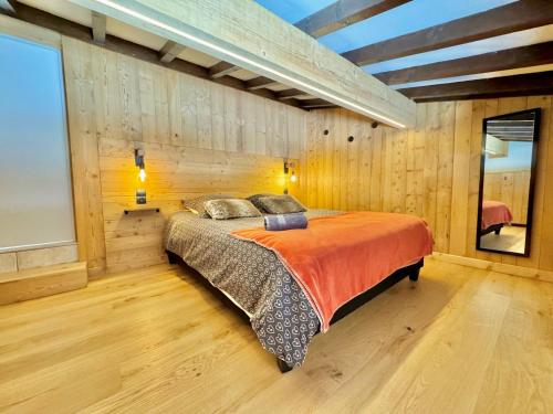une chambre avec un lit dans un mur en bois dans l'établissement Appartement calme près des pistes, rénové, 2 chambres, parking non privatif - FR-1-505-86, à Notre-Dame-de-Bellecombe