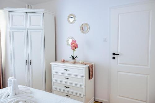 een witte slaapkamer met een dressoir en een witte kast bij Clover Apartament in Cluj-Napoca