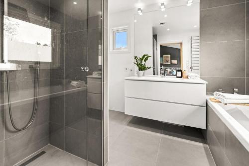 a bathroom with a shower and a sink and a mirror at Slemdal, Oslo West in Oslo