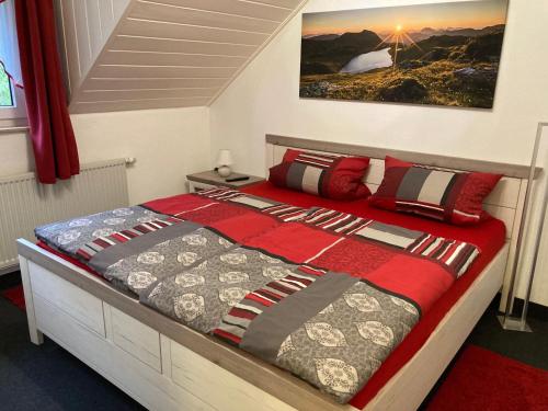 溫特貝格的住宿－Landhaus-Postwiese，一间卧室配有一张带红色和灰色枕头的床