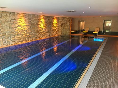 a swimming pool in a hotel with a stone wall at Landhaus-Postwiese in Winterberg