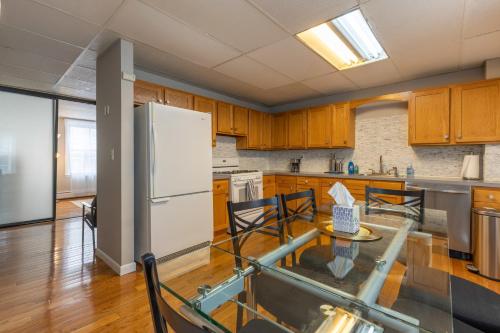 a kitchen with wooden cabinets and a white refrigerator at Central 3 Bed 1 Bath in Historic Building in Boston
