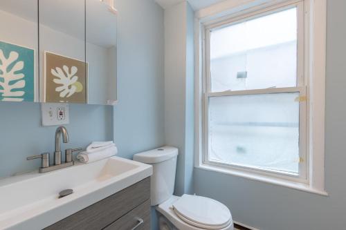 uma casa de banho com um WC, um lavatório e uma janela em Central 3 Bed 1 Bath in Historic Building em Boston