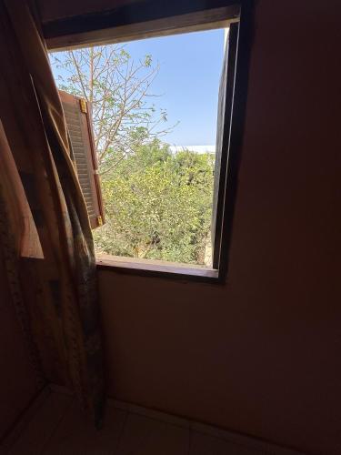 a window in a bathroom with a view of a tree at keur manga in Somone