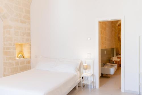 a white bedroom with a bed and a sink at Endea Suite Rooms & Lounge SPA in Matera