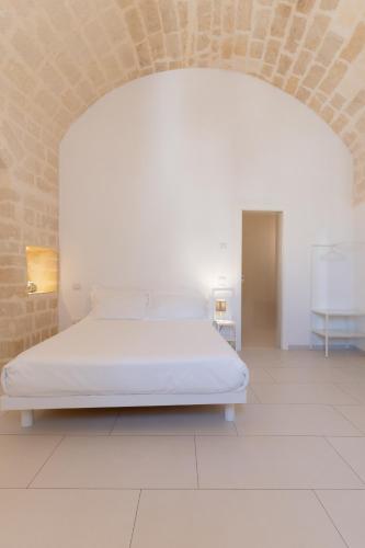 a white bed in a room with a brick wall at Endea Suite Rooms & Lounge SPA in Matera