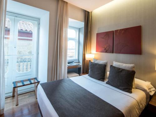 a bedroom with a large bed and a window at Hotel Carris Porto Ribeira in Porto