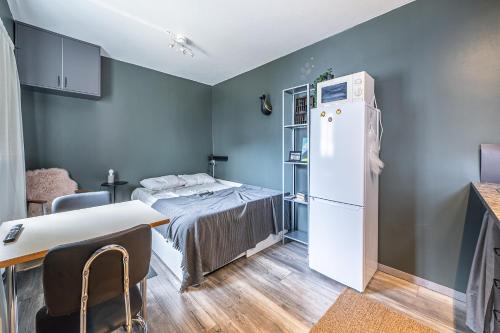 a small room with a bed and a refrigerator at Charming cottage in downtown Reykjavik - Birta Rentals in Reykjavík