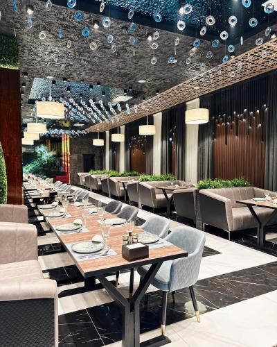 a dining room with a long table and chairs at Marmar Family Restaurant and Hotel in Nukus