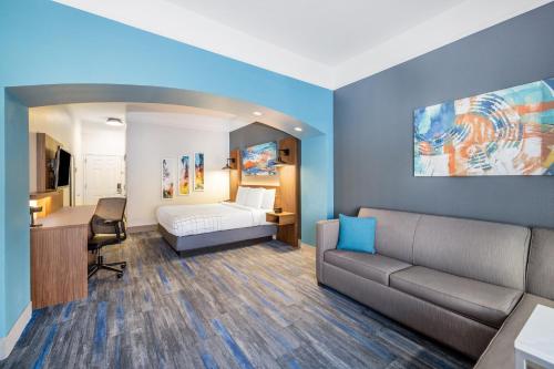 a room with a couch and a bed and a desk at La Quinta by Wyndham St. George in St. George