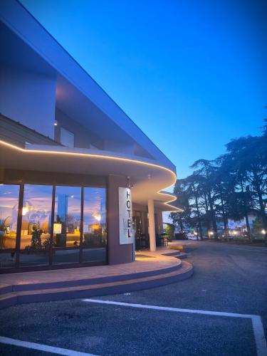 a large building with a sunset in the windows at Piccolo Hotel Nogara in Nogara