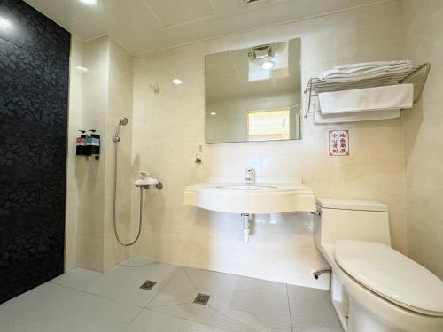 een badkamer met een wastafel, een toilet en een douche bij Ai Lai Fashion Hotel in Taichung