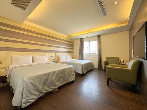 pokój hotelowy z dwoma łóżkami i telewizorem w obiekcie Ai Lai Fashion Hotel w mieście Taizhong