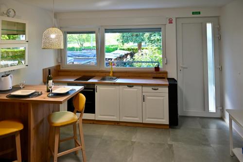 una cucina con armadi bianchi, lavandino e finestra di Studio Apartman UNA -self check in,free parking a Karlovac