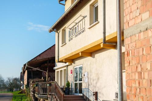 ein Gebäude mit einer Veranda und einer Außentreppe in der Unterkunft Hôtel Restaurant Ritter'hoft in Morsbronn-les-Bains