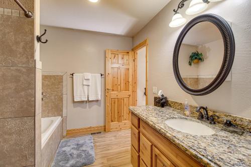 a bathroom with a sink and a tub and a mirror at Rustic Lakeside Cabin on 3 Acres w/ Nature Views! in Pinetop-Lakeside