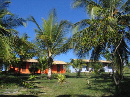 a house with palm trees in front of it at Pousada o Forte in Mangue Sêco