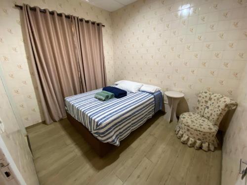 - une petite chambre avec un lit et une chaise dans l'établissement Suite Vintage, à Garibaldi