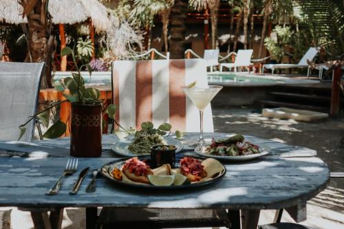 a table with two plates of food and a drink at Holbox Deluxe Apartments in Holbox Island