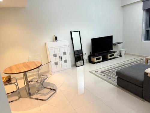 a living room with a couch and a table and a tv at 1 BHK in Al Khan Sharjah in Sharjah