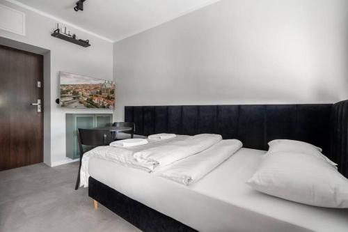 ein Schlafzimmer mit einem großen Bett mit weißen Kissen in der Unterkunft Blick Apartments - Riverside Mini Apartment in Zgorzelec