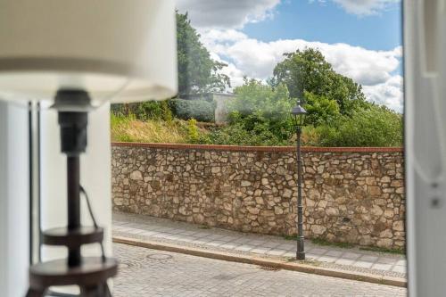 a view of a stone wall from a window at Blick Apartments - Riverside Mini Apartment in Zgorzelec