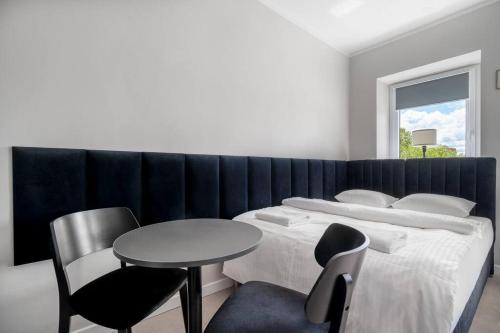 a bedroom with a bed and a table and chair at Blick Apartments - Riverside Mini Apartment in Zgorzelec