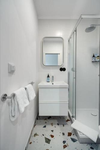 a white bathroom with a sink and a mirror at Blick Apartments - Riverside Mini Apartment in Zgorzelec