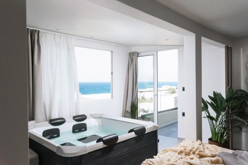 a bathroom with a bath tub with a view of the ocean at Alcyone Studios and Apartments in Heraklio Town