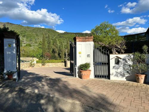 a white house with a gate and a fence at Casa Alessandra in Arezzo