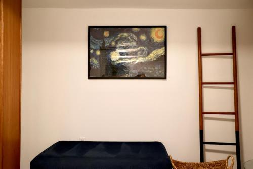 a room with a blue ottoman and a painting on the wall at Chicago North Shore Nest in Chicago