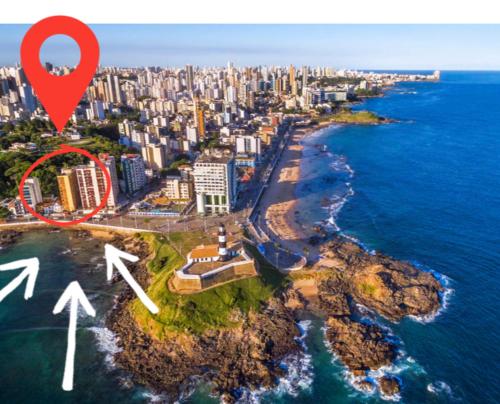een uitzicht vanuit de lucht op een stad met een rode markering bij Apartamento Vista Farol da Barra com 2 Quartos in Salvador