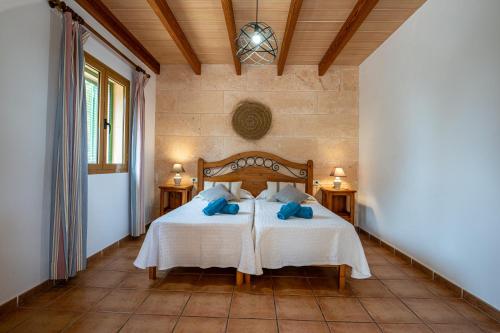 a bedroom with a bed with blue pillows at Finca Girasols in Campos