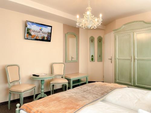 a bedroom with a bed and a table and chairs at Altstadt-Hotel in Freiberg