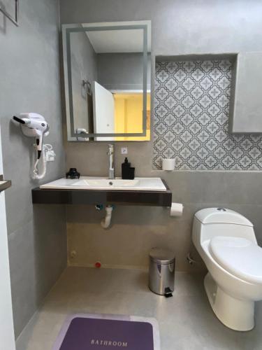a bathroom with a toilet and a sink and a mirror at Hermosa suite 2 cerca de todo in Guayaquil