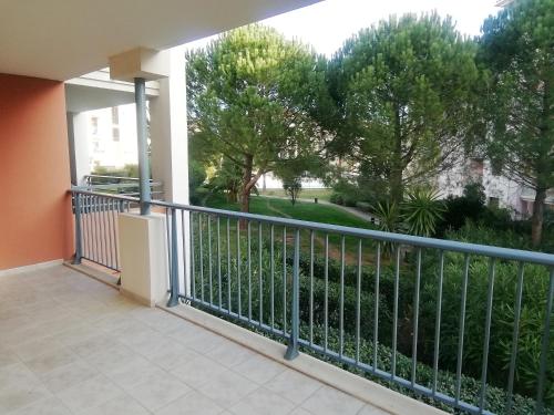 un balcón con una barandilla con árboles en el fondo en Superbe appartement dans résidence avec piscine en Saint-Aygulf